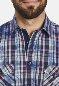 Kurzärmliges karierter Hemd in Blau, Grün und Rot, mit zwei Brusttaschen, Knopfverschluss und gestickten Initialen auf der Tasche.