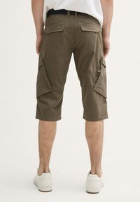Brune cargo shorts lavet af letvægtsstof, med sidelommer, en afslappet pasform og en kant, der når lige over knæene.