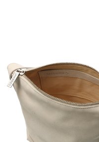 Borsa in pelle beige con chiusura a zip, che presenta una texture liscia e un design semplice. Interno foderato in tessuto beige, con etichetta del marchio.