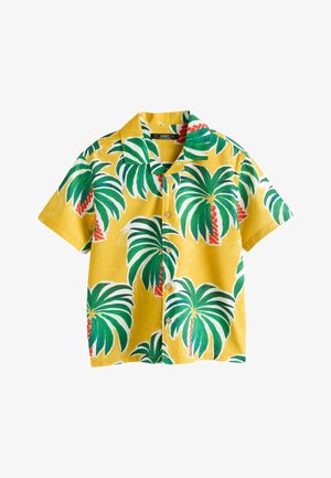 Gelbes kurzärmeliges Hemd mit Knöpfen, bedruckt mit grünen und weißen Palmen und roten Stämmen, flach auf weißem Hintergrund gelegt.