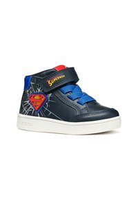 Sneakers alti navy con lacci blu, cinturino in velcro, accenti rossi e un patch con il logo di Superman. Presentano una suola in gomma bianca testurizzata.