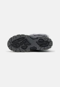 Semelle de botte de randonnée gris avec un design en caoutchouc texturé, comportant des motifs de semelle agressifs pour une adhérence et une durabilité accrues. Marque intégrée visible.