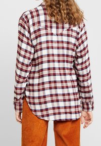 Karierte Flanellhemd in Creme-, Rot- und Blau-Tönen, mit langen Ärmeln, abgerundetem Saum und zwei Rückentaschen. Strukturierter Stoff, lockere Passform.