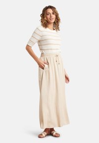 Maxi-jurk met een aansluitende, gestreepte gebreide top in cr6me en beige, een taille met een ceintuur en een vloeiende, lichtgewicht beige rok met zijzakken.