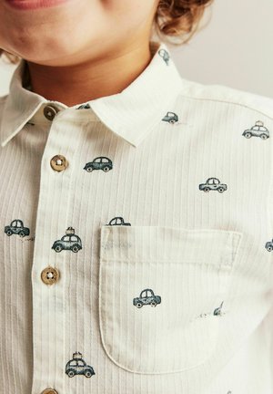 Lysefarvet skjorte med knapper, der har et tyndt stribet mønster og små blå bilmotiver. Inkluderer en brystlomme og træknapper.