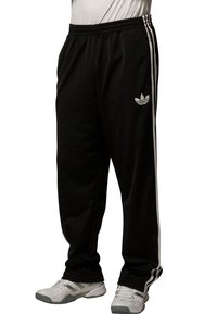 Czarne spodnie sportowe wykonane z gładkiego materiału, z białymi paskami po bokach i małym białym logo na lewej nodze.