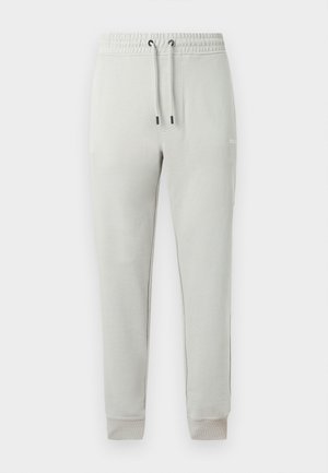 Ανοιχτό γκρι παντελόνι φόρμας με στενή γραμμή, ελαστική μέση, ρυθμιζόμενο κορδόνι, μανσέτες στους αστραγάλους και μικρό λευκό λογότυπο στο δεξί μηρό.