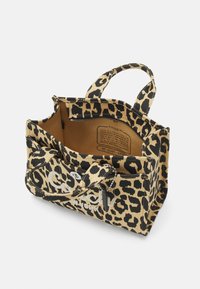Sac fourre-tout en toile à imprimé léopard avec deux poignées supérieures, poche intérieure et doublure marron contrastée. Il possède des finitions en métal argenté.
