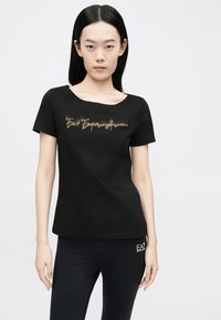 Fekete, rövid ujjú, pamutból készült póló mélynyakkal, arany csillogó szöveges mintával: "EA7 Emporio Armani."