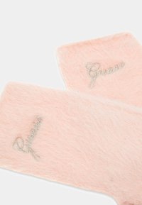Guanti in pelliccia rosa con la scritta "Guess" ricamata in argento. Texture morbida con forma rettangolare e senza ulteriori accenti.