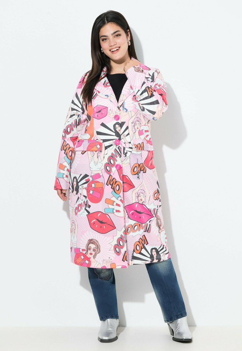 Cappotto lungo grafico con un fondo rosa decorato da stampe di labbra in stile cartone animato, icone di bellezza e testo audace; rifinito con grandi bottoni rosa e tasche.