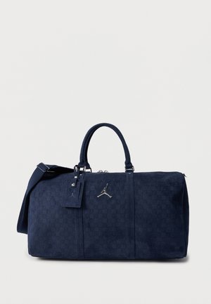 Borsa da viaggio blu navy con motivo a trama, due manici, tracolla staccabile e logo Jumpman argentato sul davanti.