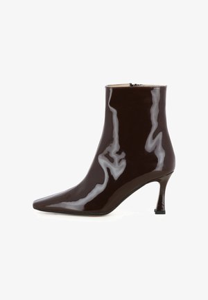Braune Lackleder-Stiefelette mit spitzem Zehenbereich, schlankem Absatz und Reißverschluss hinten. Glatte Textur mit glänzendem Finish.