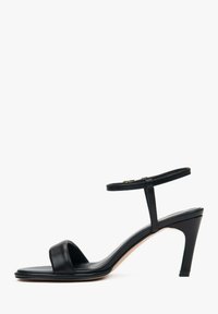 Zwarte leren haksandalen met een brede voorkantband, een dunne verstelbare enkelband en een slanke, taps toelopende hak. Glad textuur, minimalistisch ontwerp.