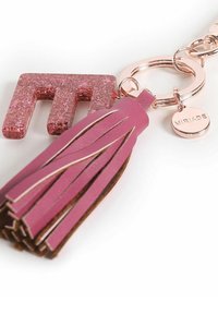 Portachiavi con una lettera 'M' glitterata in rosa e un tassello in pelle rosa, attaccato a un anello in oro rosa con un'etichetta incisa "MIRIADA."