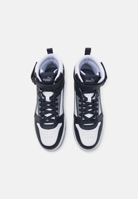 Höga sneakers i svart och vitt läder med strukturerade paneler och vadderad krage. Utrustade med snören och en remdetalj nära vristen.