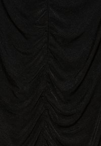 Tissu noir avec un éclat texturé, caractérisé par des drapés horizontaux et des sections froncées tout au long, créant une apparence fluide et lisse.