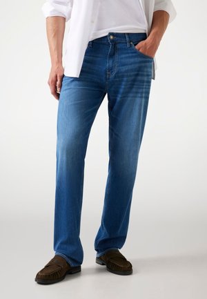Blue denim jeans with a straight leg fit, featuring a front pocket, button closure, and subtle fading. Paired with brown loafers.