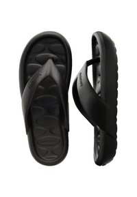 Fekete flip-flop papucs texturált talprésszel és T-strap dizájnnal. Tartós gumiból készült, az oldalán a márka neve gravírozva.