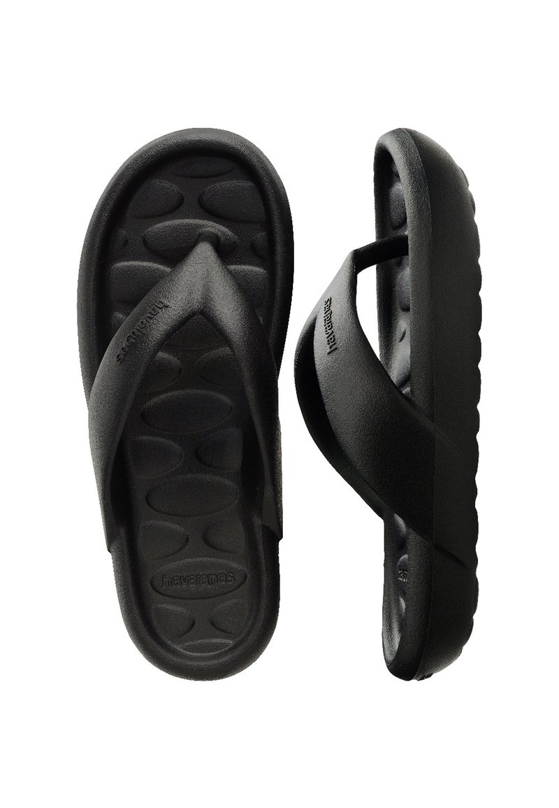 Fekete flip-flop papucs texturált talprésszel és T-strap dizájnnal. Tartós gumiból készült, az oldalán a márka neve gravírozva.