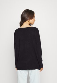 Μαύρος υπερμεγέθης ζακέτα με χαλαρή εφαρμογή, φαρδύ λαιμόκοψη και ριγέ τελείωμα. Διαθέτει μακριά μανίκια και μαλακή πλέξη.