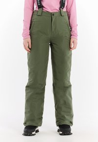Groene waterdichte skibroek met verstelbare bandjes, brede pijpen, zijzakken en een gladde textuur, gecombineerd met zwarte winterlaarzen.