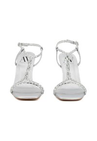 Sandali con tacco alto argentati caratterizzati da un design a strisce, adornati con rhinestone trasparenti e una zona della punta liscia e riflettente.