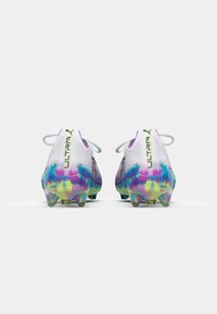 Football boots with a white synthetic upper, colorful gradient pattern in pink, blue, and yellow on the sole, and contrasting green logo.