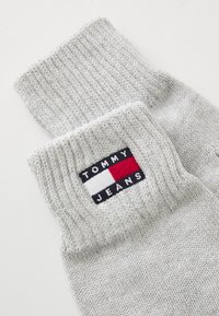 Sivé pletené ponožky s rebrovaným eenmaalom a obdĺžnikovou nášivkou s červenou, bielou a modrou farbou, označené "TOMMY JEANS."