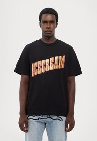 Black cotton t-shirt featuring "ICECREAM" text in yellow and red, with a graphic design. Short sleeves and crew neck style.