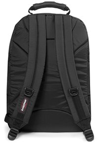 Mochila negra con correas de hombro acolchadas, un panel trasero texturizado y un asa duradera. Presenta un parche del logo en una de las correas.