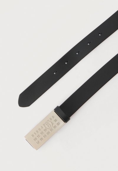 Μαύρη δερμάτινη ζώνη με ορθογώνια ασημένια αγκράφα που φέρει χαραγμένους αριθμούς από το 0 έως το 23, με έμφαση στον αριθμό 6 σε κύκλο.