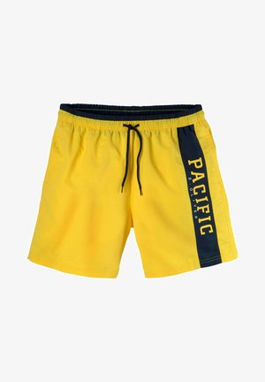 Gelbe Badehose mit schwarzem Bund und Kordelzug. Das seitliche Paneel zeigt "PACIFIC" in großen Buchstaben. Glattes, leichtes Material.