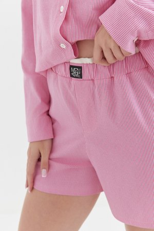 Różowe spodenki piżamowe w paski, wykonane z miękkiego materiału, z elastycznym pasem i metką z logo z tyłu. Dołączona koszulka ma dopasowane paski.