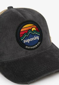 Dunkelgraue Cordura-Baseballmütze mit einem bunten Bergsunset-Patch, das auf dem vorderen Panel mit "superdry outdoor co." beschriftet ist.