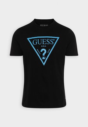 Czarny bawełniany t-shirt z dużym niebieskim trójkątnym logo z napisem "GUESS" oraz "U.S.A.". Krótkie rękawy i klasyczny design z okrągłym dekoltem.