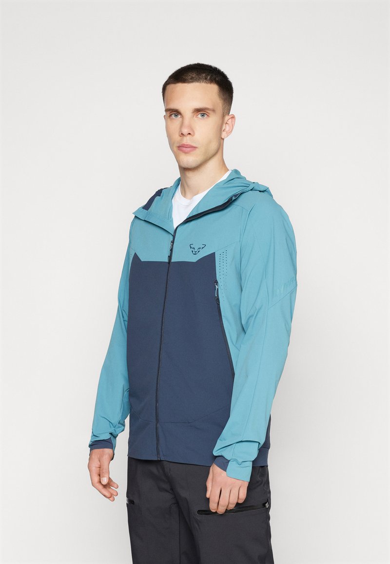 Leichte Jacke mit einem Design aus blauen und marineblauen Farbbereichen, Vollreißverschluss, verstellbare Kapuze, seitlichen Reißverschlusstaschen und atmungsaktiven Stoff.
