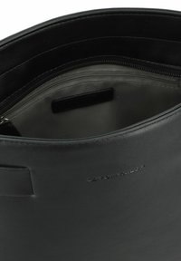 Borsa in pelle nera con una texture liscia, scomparto con zip e interno grigio. Logo impresso all'esterno. Design minimalista.