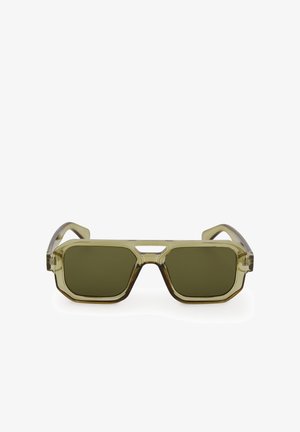 Olive green sunglasses with a transparent olive frame, geometric design, wide rectangular lenses, and a central cut-out feature.