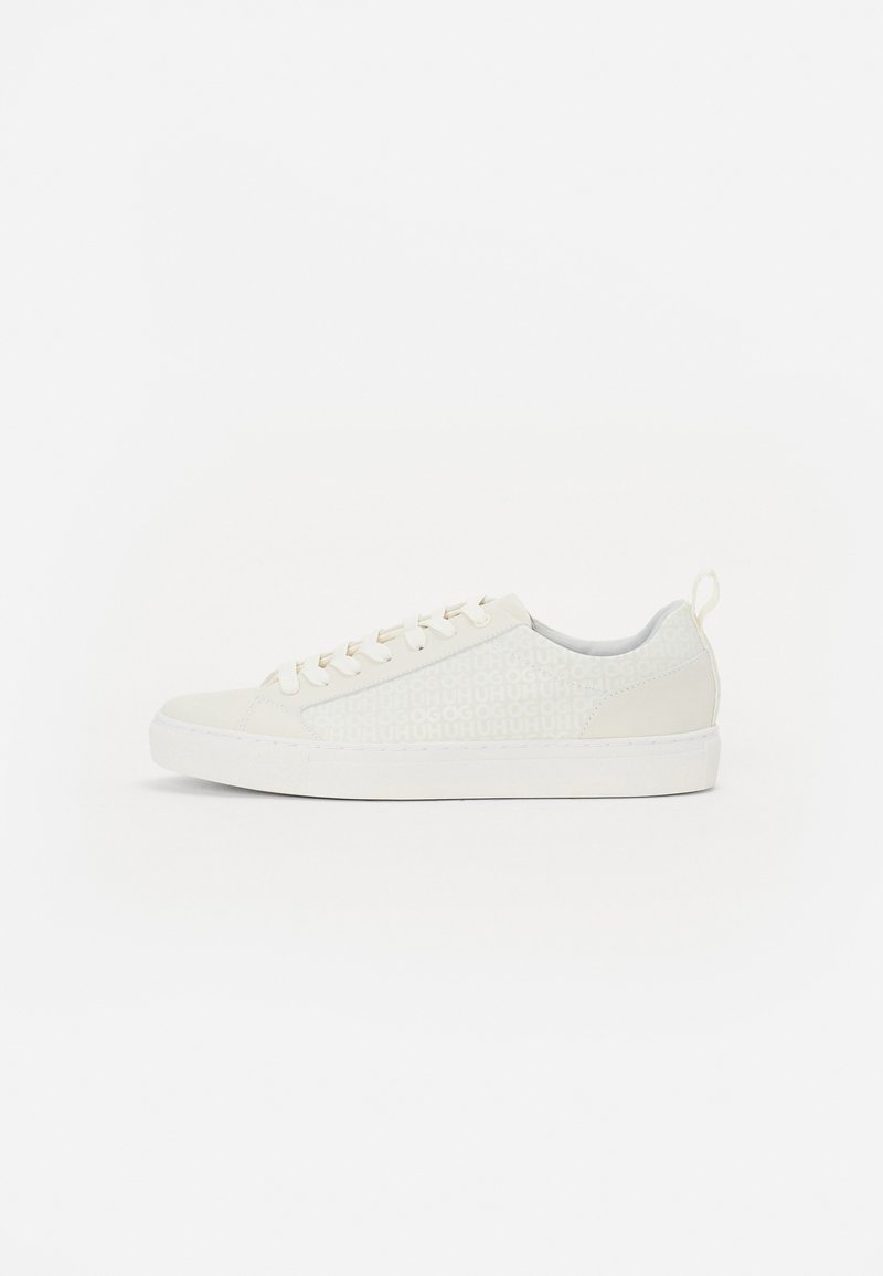 Sneaker alb cu suprafață texturată, având un model geometric. Vârf rotund, șireturi albe și o talpă de profil jos.