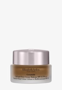 Tarro de maquillaje con crema de ceramida, con base de vidrio esmerilado, tapa metálica plateada y texto negro que detalla el nombre del producto y SPF.