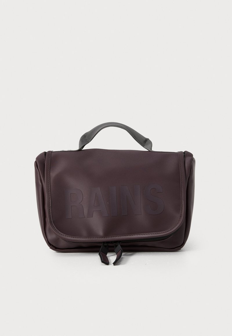 Kisméretű, sötétlila, vízálló anyagból készült táska, hajtogatható tetejű fedelekkel, diszkrét logóval, felső fogantyúval és cipzáras záródással.