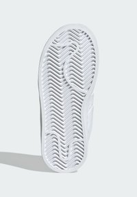 Bijeli potplat tenisice s teksturiranim uzorkom riblje kosti, zaobljenim rubovima i čistim, glatkim gumenim završetkom.