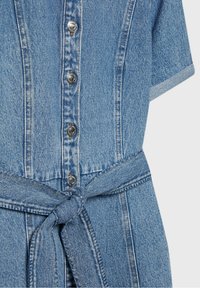 Robe en denim à manches courtes, avec un devant boutonné et une taille nouée. Couleur bleu clair avec des coutures classiques et des boutons en métal. Texture lisse.