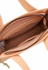 Borsa color pesca con cerniera nera aperta che mostra l'interno vuoto foderato in tessuto, tasca interna con cerniera e due manici.