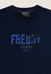 T-shirt in cotone blu navy con una stampa grafica che riporta la parola "FREDDY" in blu e grigio, completata dalla dicitura "TRAINING DEPT." sottostante.