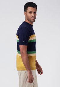 Suéter de punto de manga corta, en color azul marino con rayas horizontales en verde, amarillo y beige. Cuello y dobladillo de canalé, diseño ajustado.