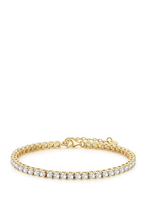 Pulsera de tenis de oro con una fila de piedras preciosas redondas y transparentes y un cierre de langosta sobre un fondo blanco.