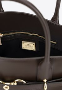 Brązowa skórzana torebka z złotym zamkiem błyskawicznym i akcesoriami. Posiada wewnętrzną płytkę z logo. Gładka tekstura o usztywnionym fasonie i wewnętrznej kieszeni.