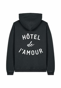 Fekete kapucnis pulóver, fehér "HÔTEL de L'AMOUR" felirattal a hátsó részén, bordás mandzsettákkal és alsó szegéllyel.